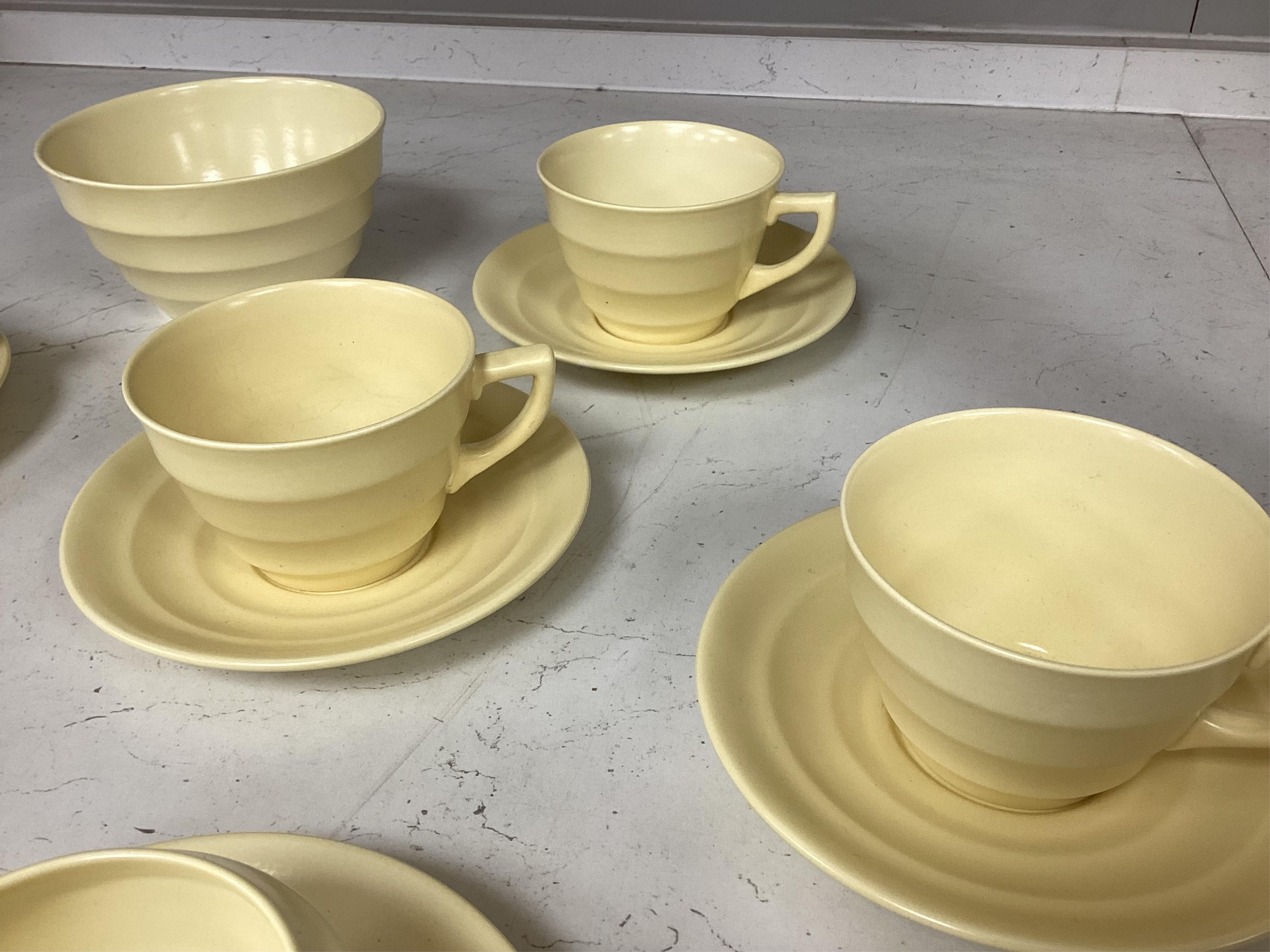A part-set of Keith Murray Wedgwood teaware in matt straw, five cups and saucers, milk jug, sugar bowl and a spare saucer